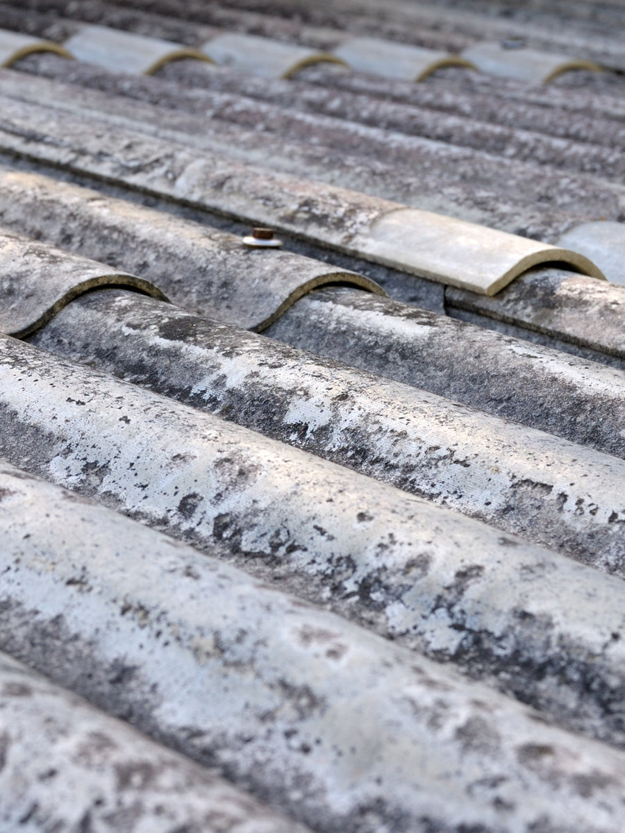 Old weather-beaten tile roof before replacement